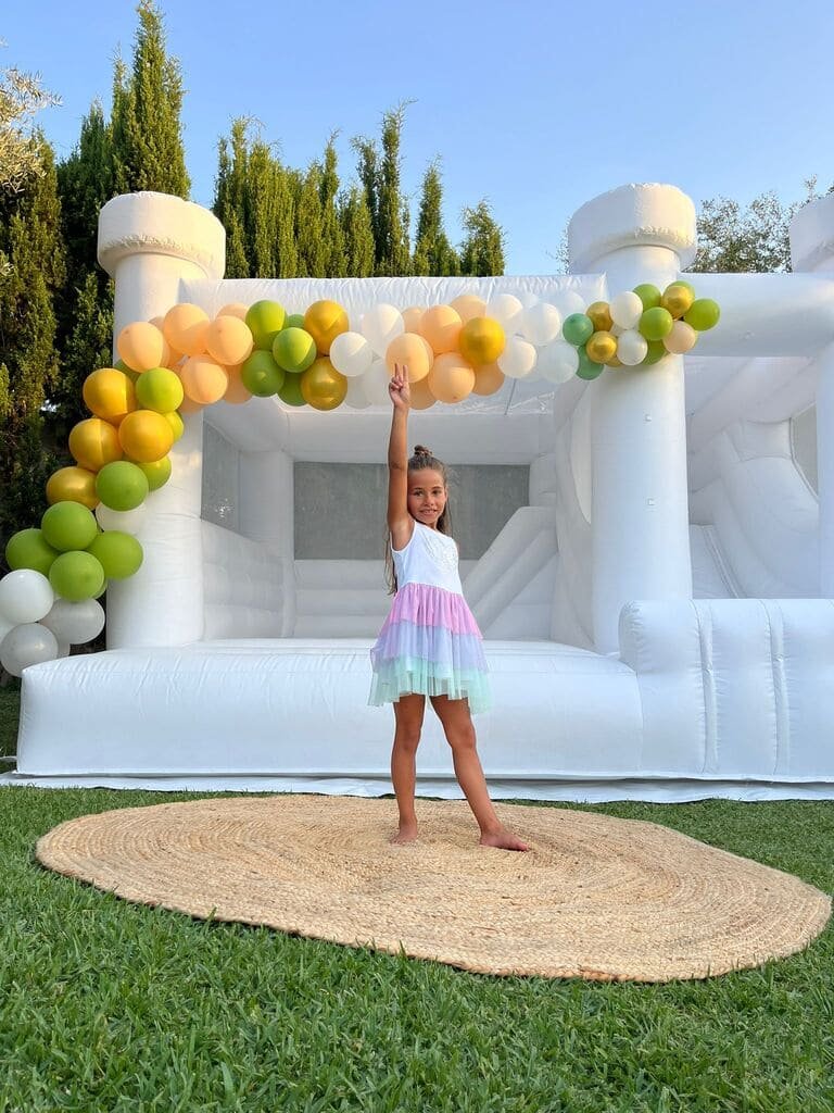 nino jugando castillo hinchable blanco