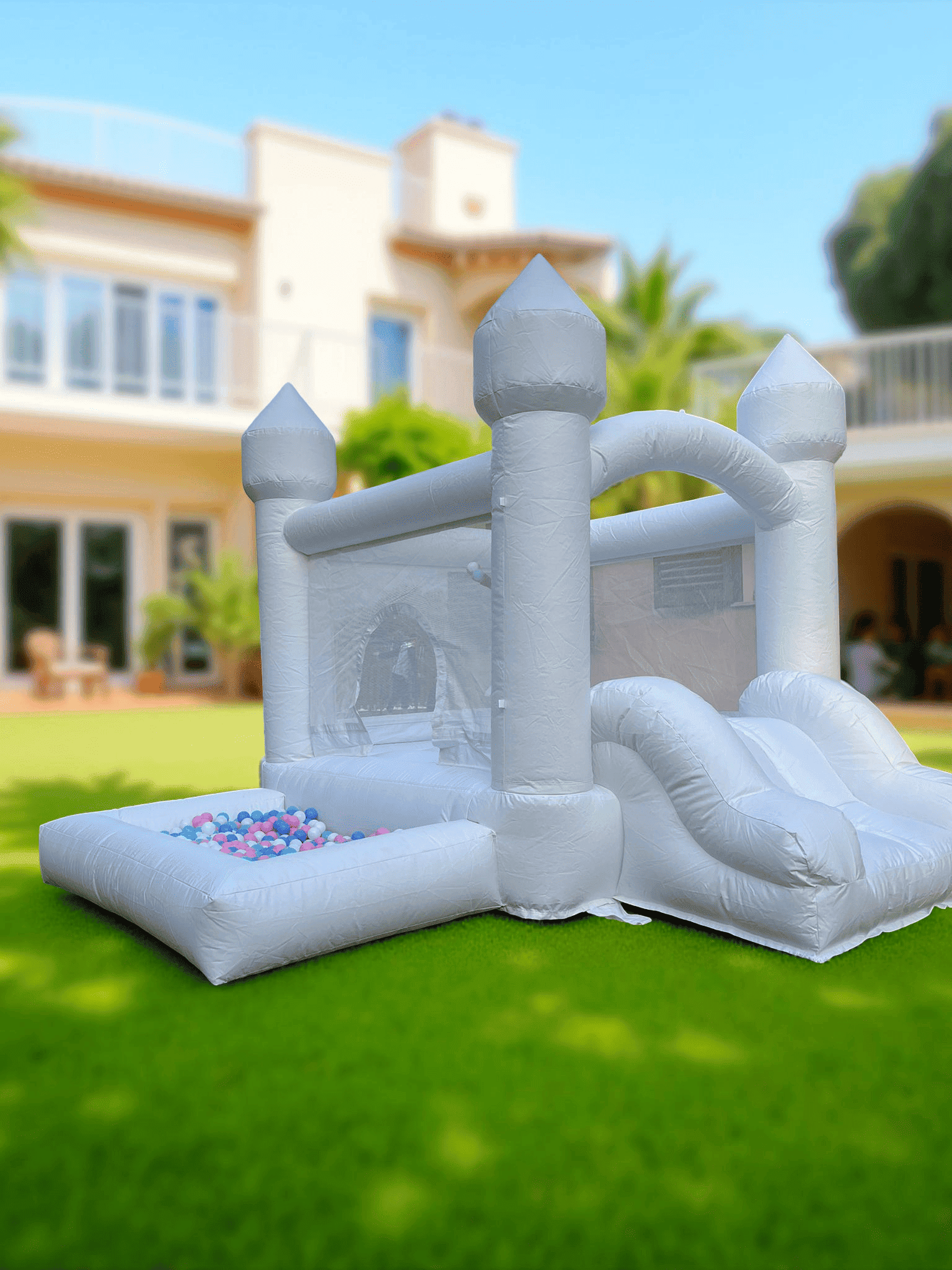 castillo hinchable blanco decorado con globos