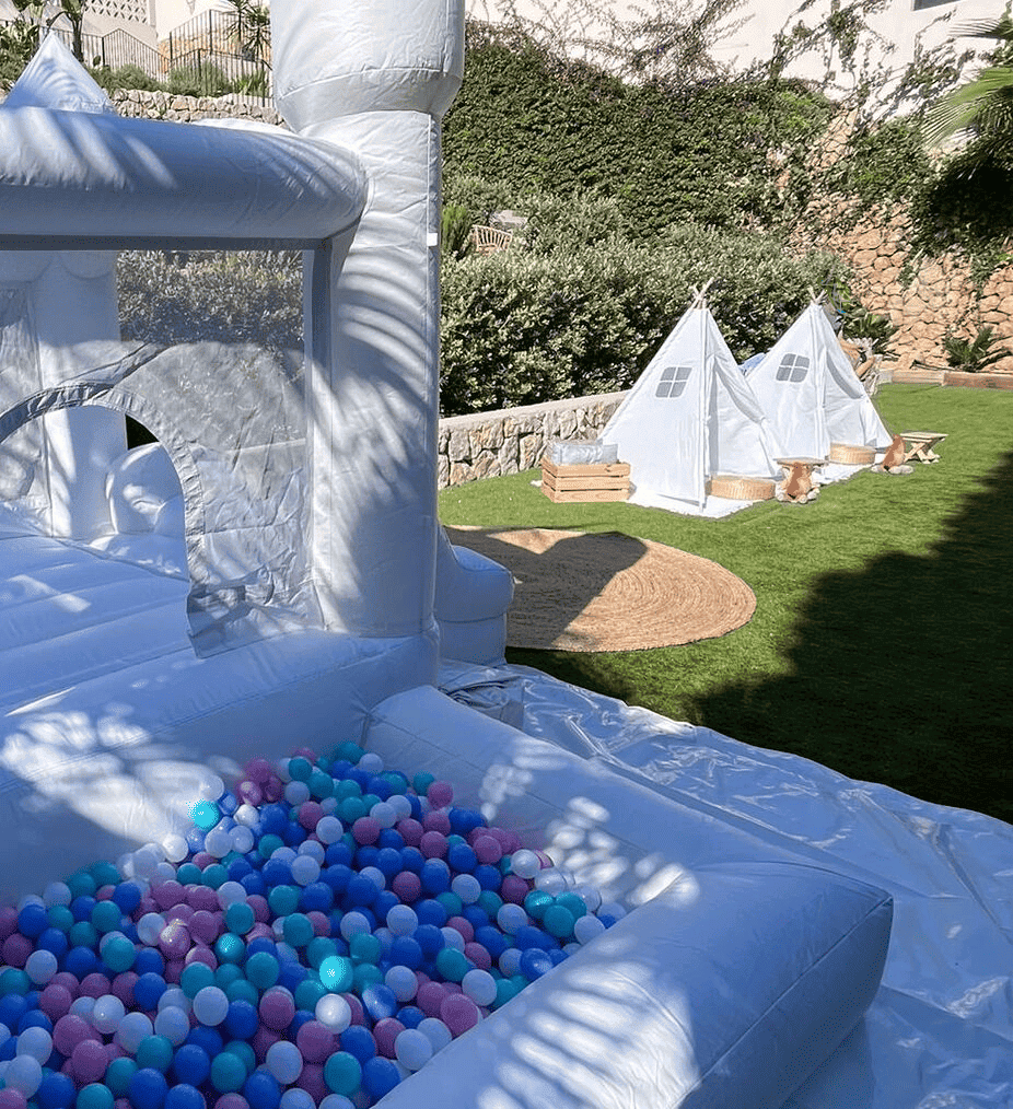 castillo hinchable blanco decorado con globos