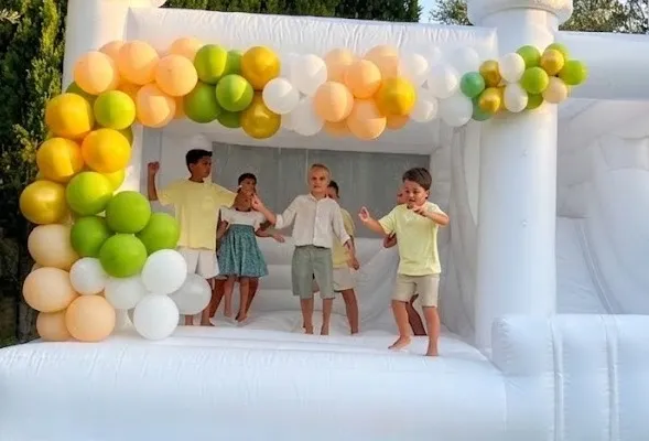 niños jugando en castillo hinchable blanco